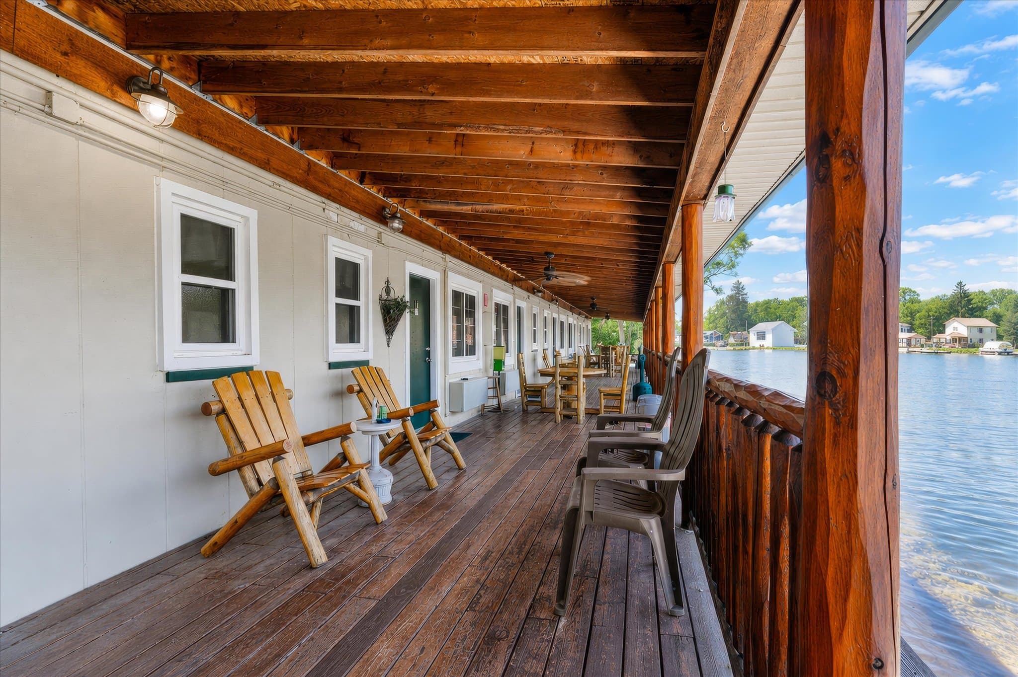 Covered lakeside deck with log chairs at Olde Mill Inn of Clarkston