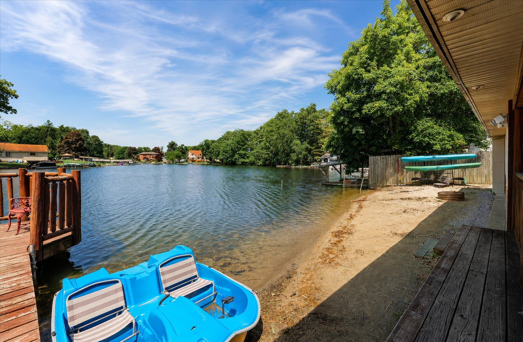 Sandy beach with a pedal boat and kayaks at the water's edge at Olde Mill Inn of Clarkston
